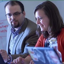 Taylor and a smiling student working at a laptop